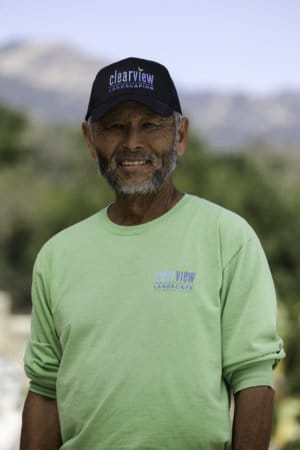 An older man wearing a green shirt and hat.
